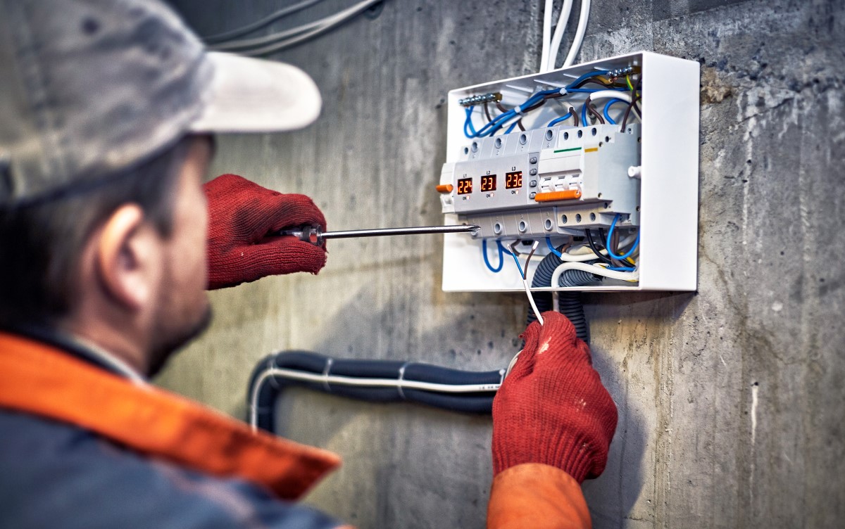 Photo of electrician working on wiring on a panel
